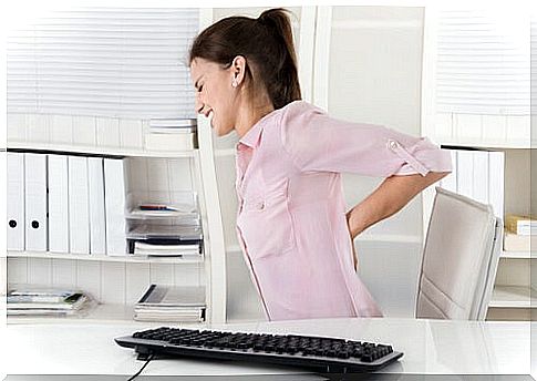 woman with back pain in office