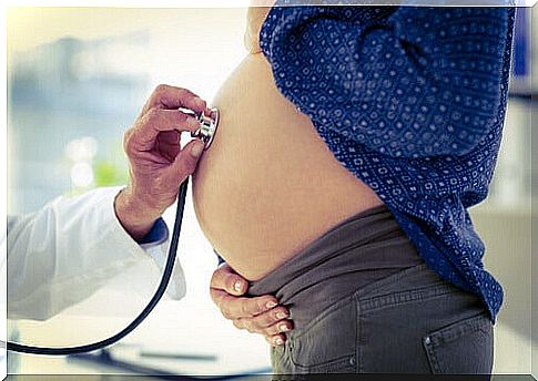 Doctor listening to the gut of a pregnant woman