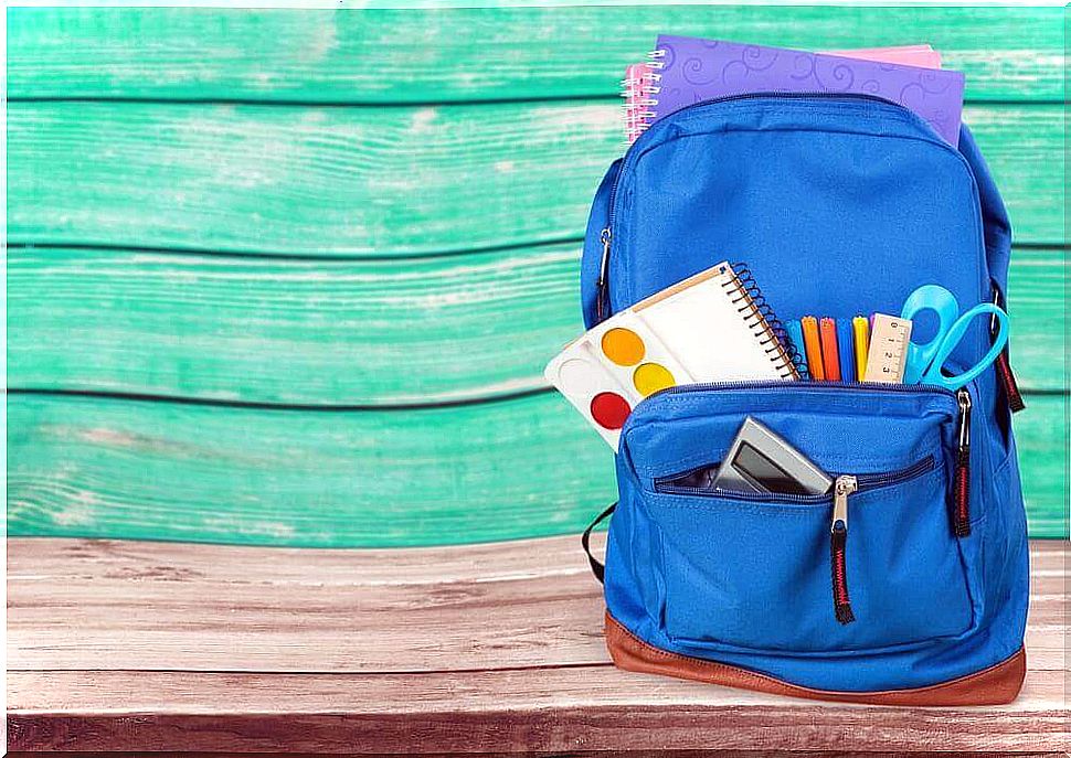 Blue backpack with notebooks, markers, scissors and calculator.