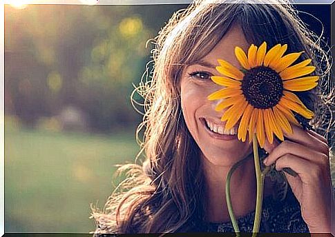 Happy woman with a sunflower on her face