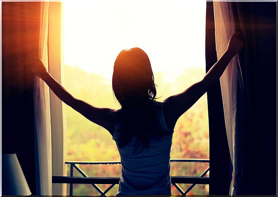 Woman opening the curtains and needing to control anxiety